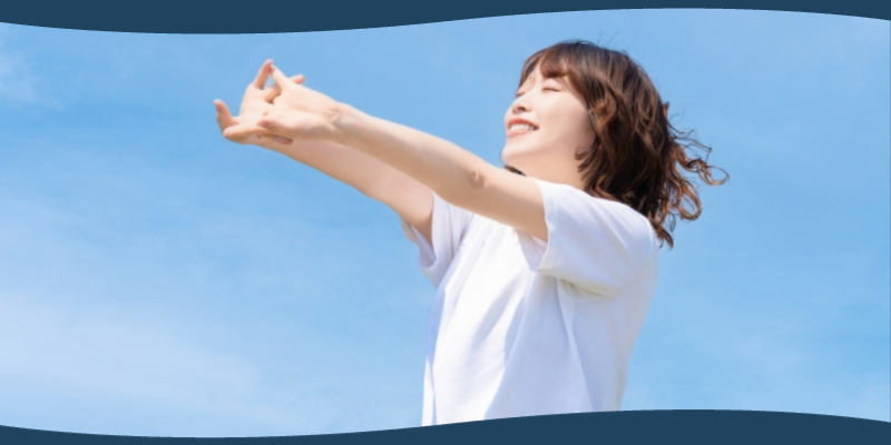 大きく深呼吸をしてリラックスする女性